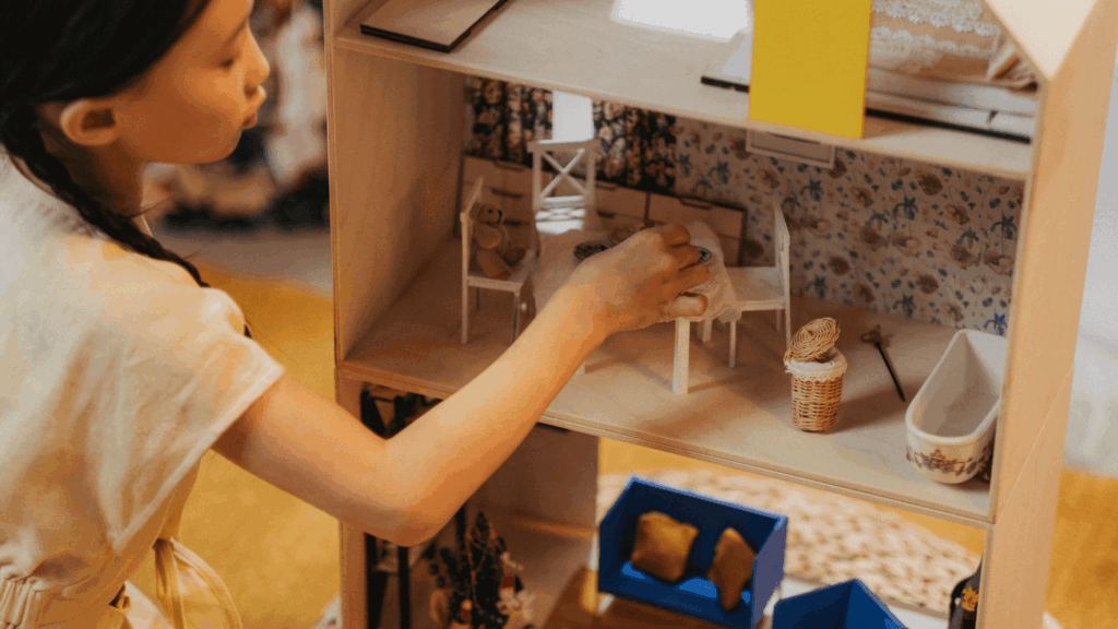 Young girl playing with doll house