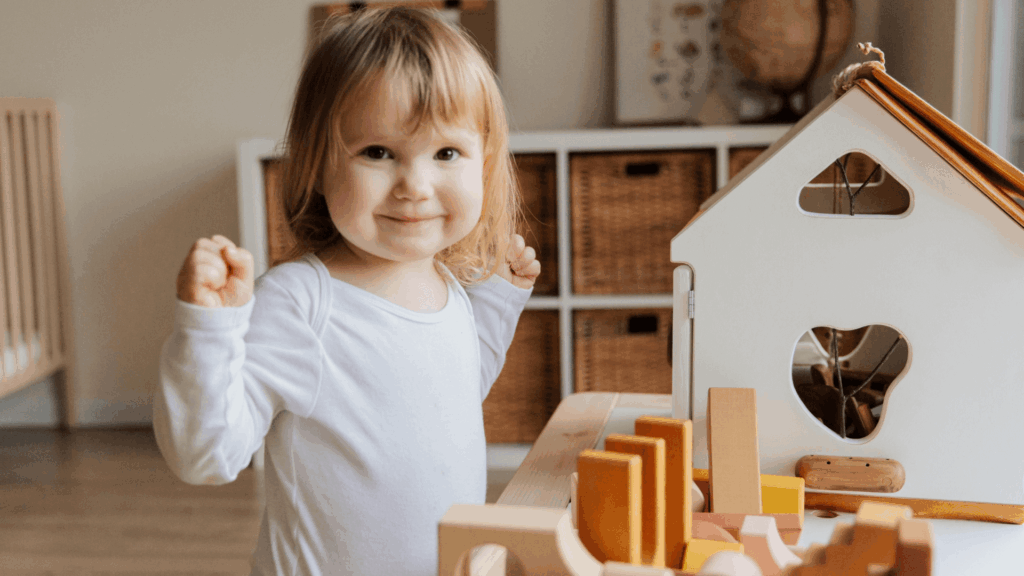 Young girl playing with doll house and toys