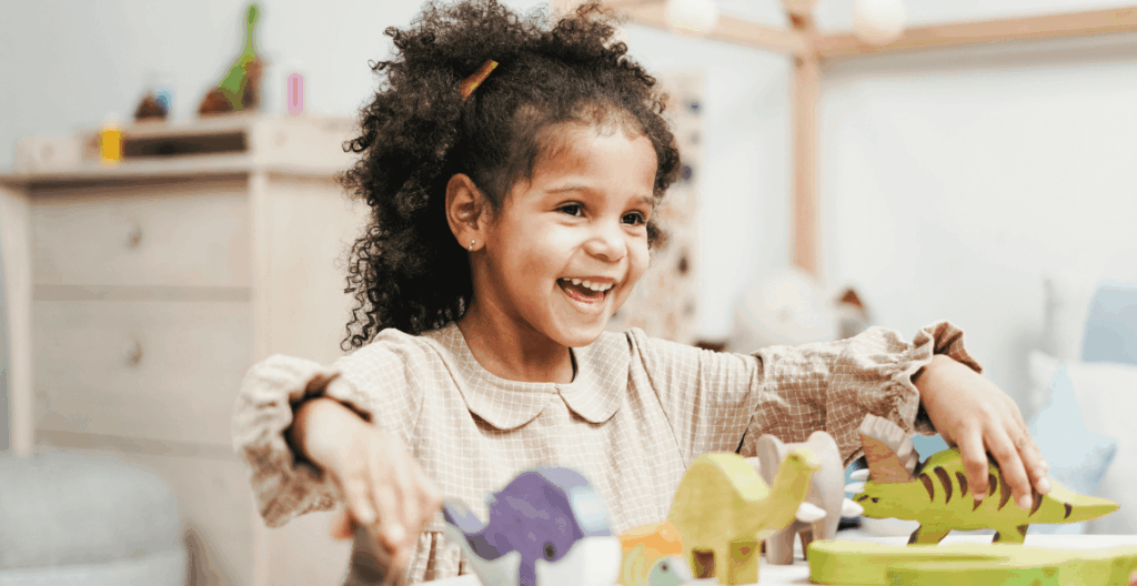 Young girl smiling and playing with animal blocks